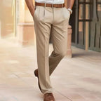 Beige pleated dress pants shown from behind, styled with a tan leather belt and brown shoes