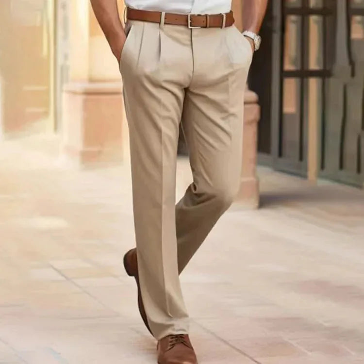 Beige pleated dress pants shown from behind, styled with a tan leather belt and brown shoes