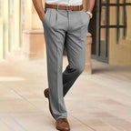 Grey tailored trousers with pleated front pockets, worn with a brown belt and lace-up shoes