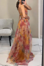 Side view of orange floral maxi dress highlighting the open waist cutout and pleated skirt