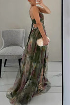 Side profile of green floral maxi dress showing open back and pleated train with gold heels