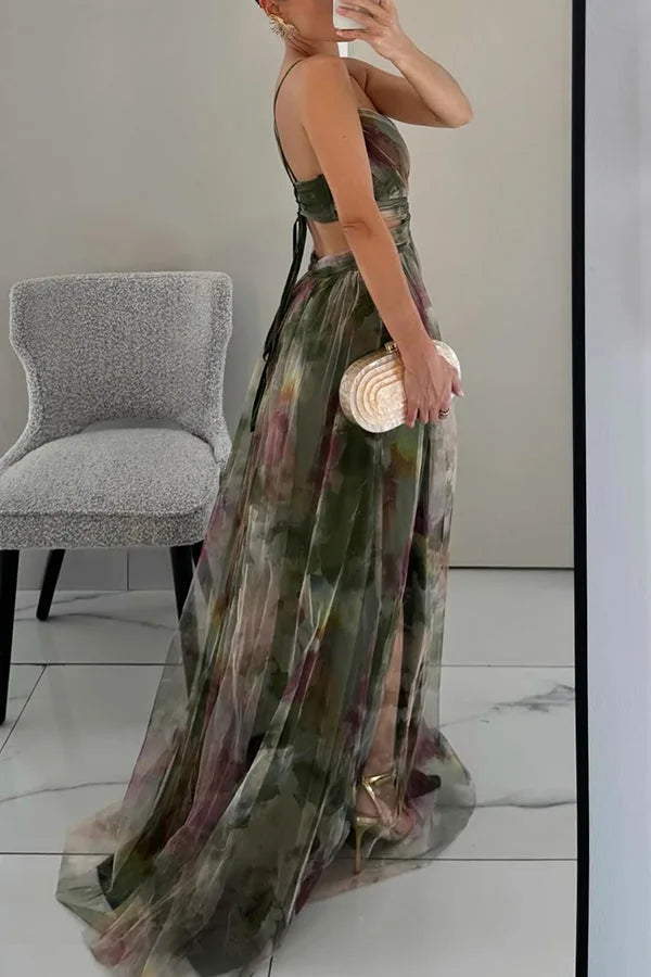 Side profile of green floral maxi dress showing open back and pleated train with gold heels