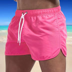 Side view of hot pink swim shorts showing the side pocket and dolphin-style curved hem detail