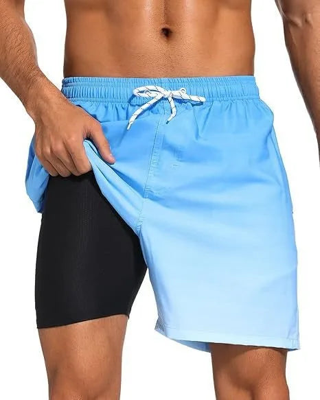 Full front view of navy tropical print swim shorts on a beach background showing overall length and fit