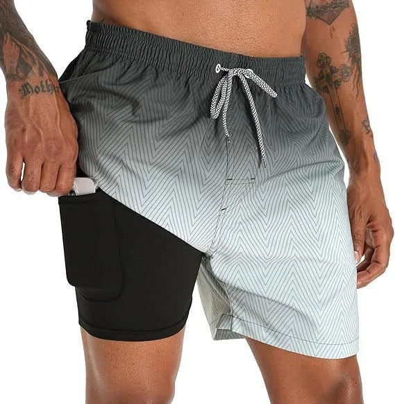Side profile of grey ombre chevron-print swim shorts with black compression liner and hand in phone pocket