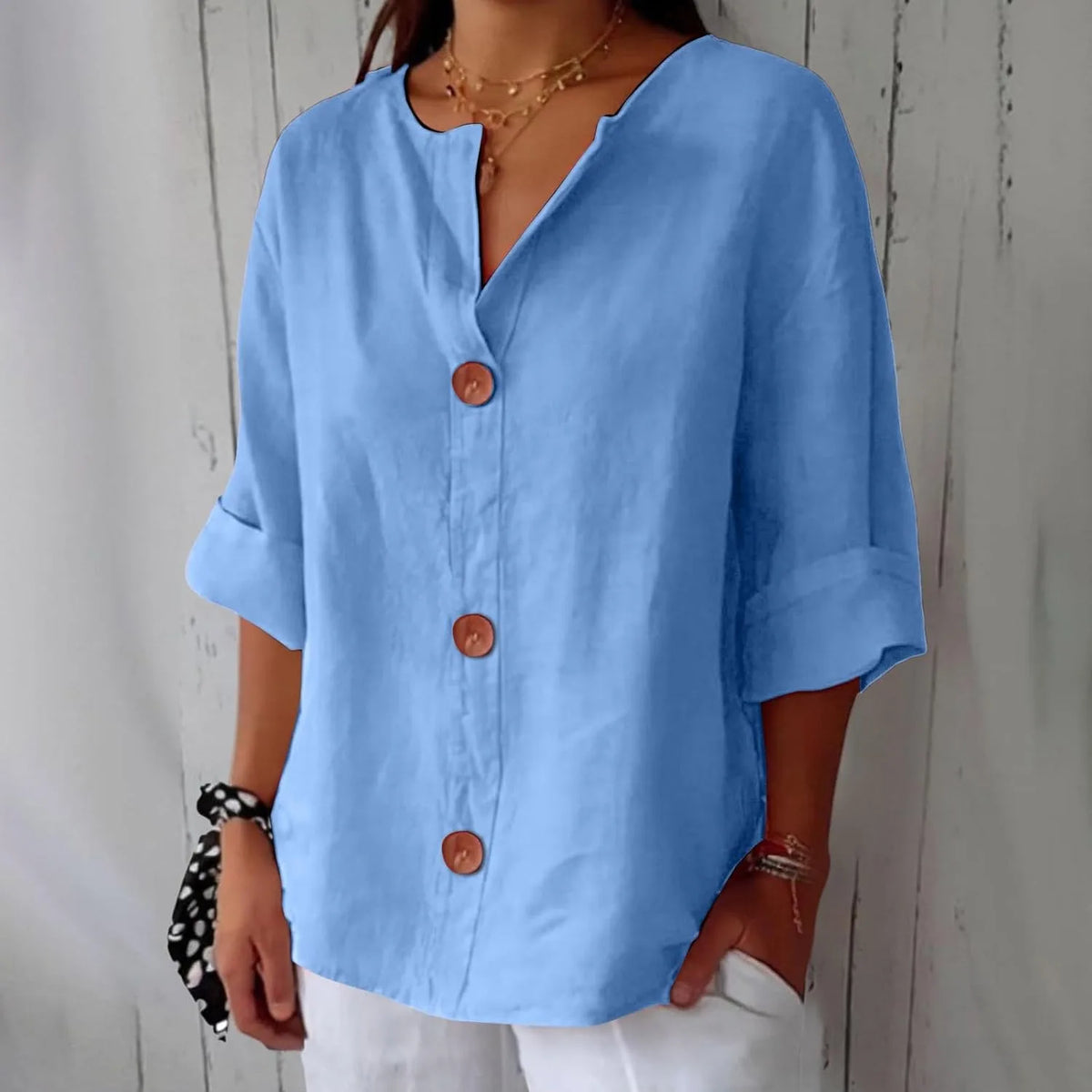Mustard yellow blouse worn against a plain white backdrop, showing the loose silhouette and button placket