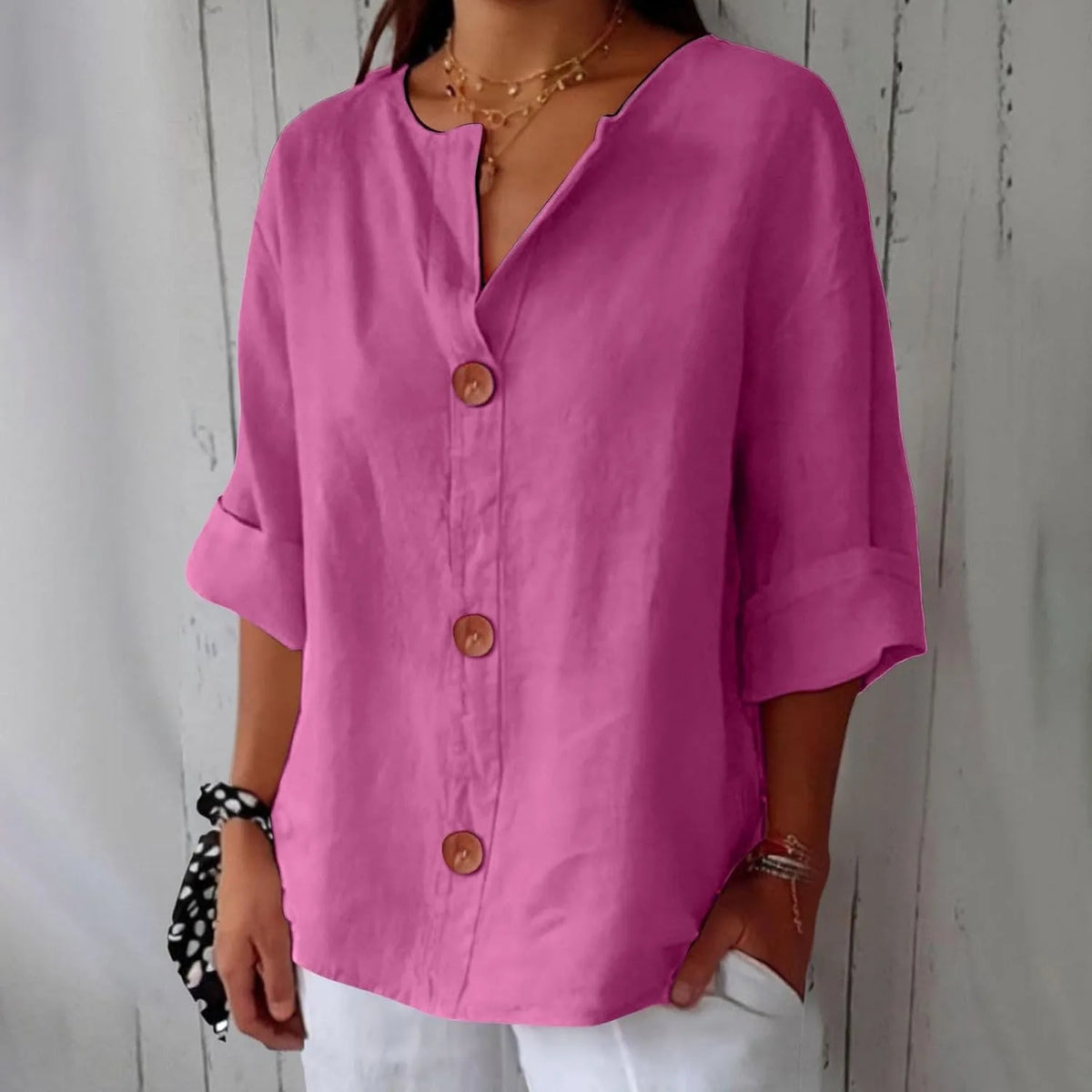 Cream blouse shown with hand in pocket of white trousers, highlighting the relaxed hemline