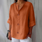 Lilac blouse close-up showing the notch V-neck and delicate gold layered necklaces