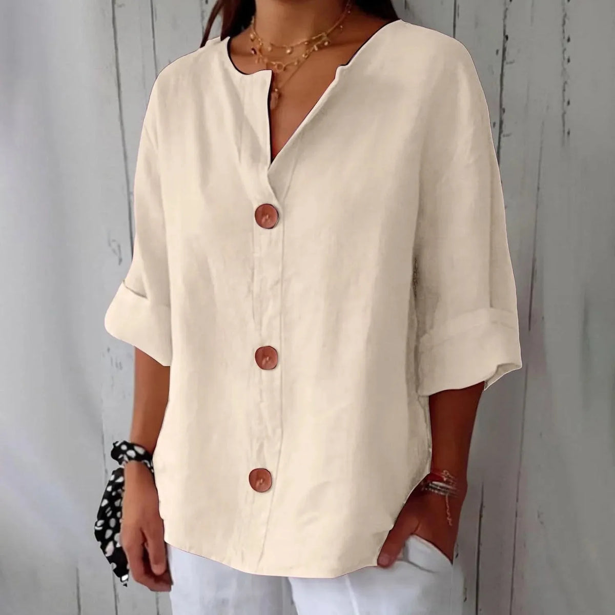 Navy blouse close-up focusing on the V-neckline trim and top wooden button