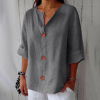 Grey relaxed-fit button-down blouse with notch neckline and cuffed sleeves, styled with white trousers