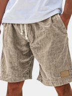 Close-up back view of khaki linen-look cotton shorts with drawstring waist, worn with white t-shirt
