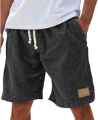 Front angle of khaki cotton shorts showing elastic waistband, side pockets and leather-look patch