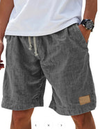 Sage green cotton shorts worn with white t-shirt, back view showing drawstring and patch detail