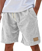Light denim-blue cotton shorts, front view showing relaxed cut and hem patch detail