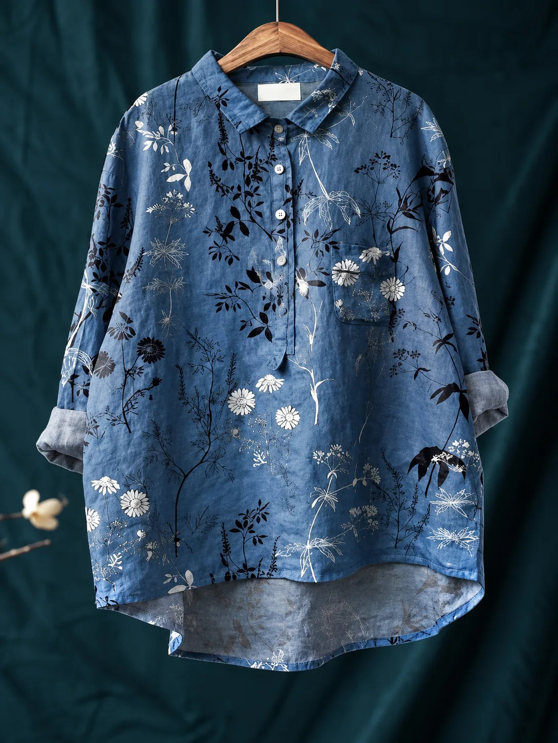 Detail shot of the button-down placket with white buttons against the floral linen fabric