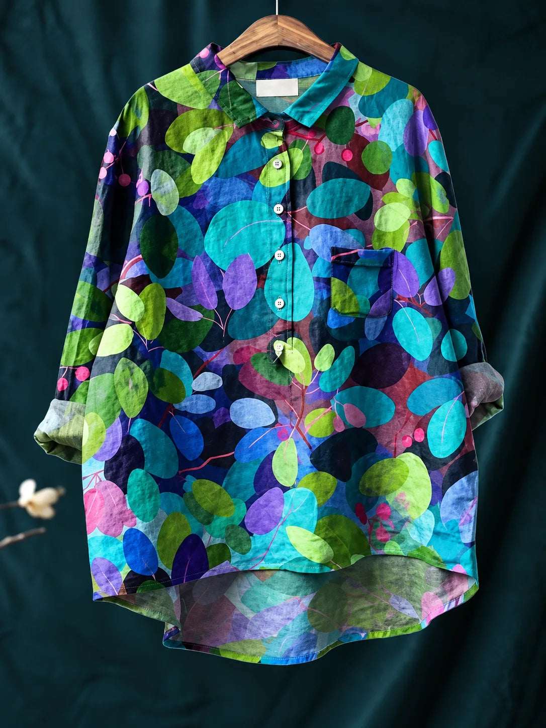 Close view of the collar and button placket showing the relaxed drop shoulder and curved hem