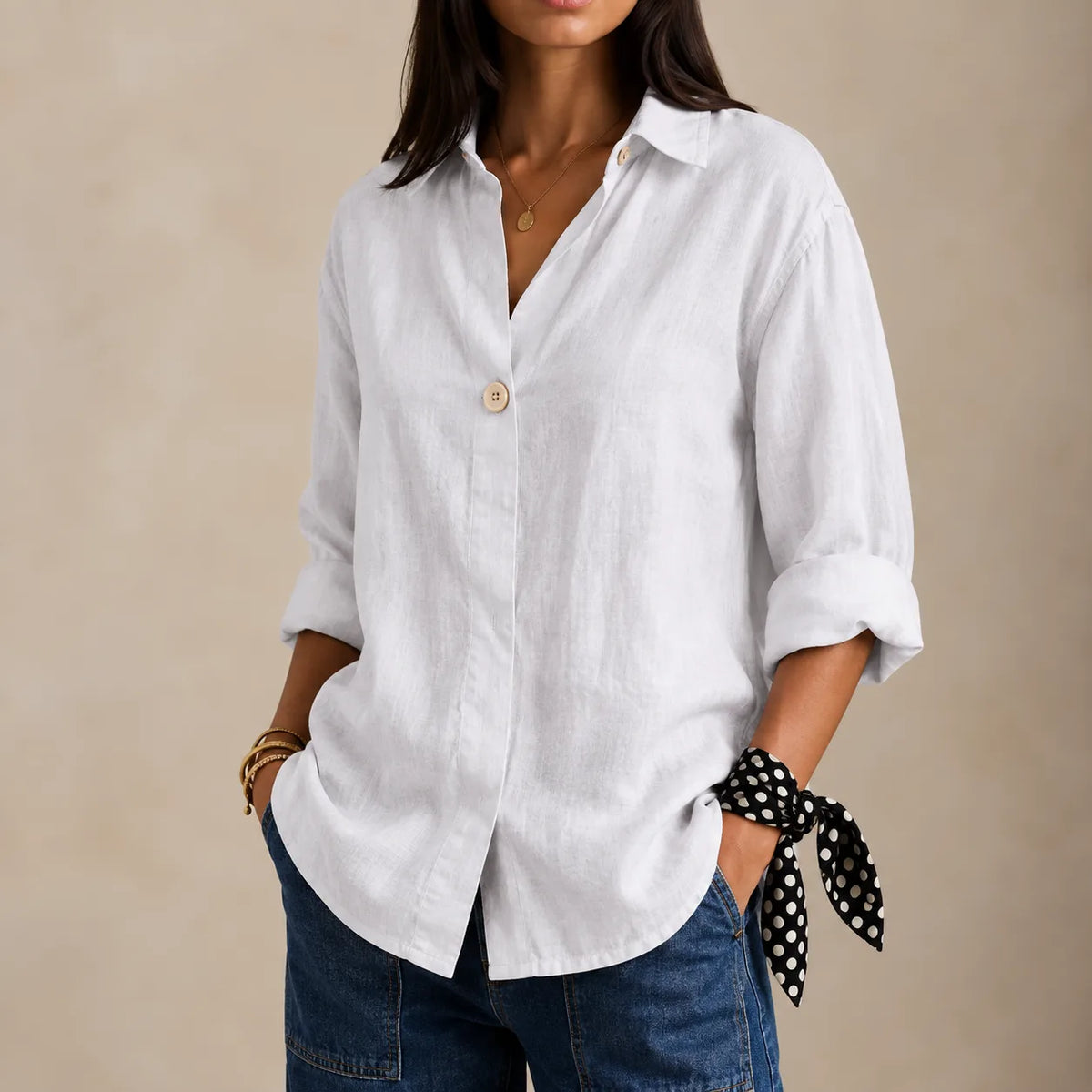 White linen blouse with open collar and single front button, styled with denim and a polka dot wrist scarf