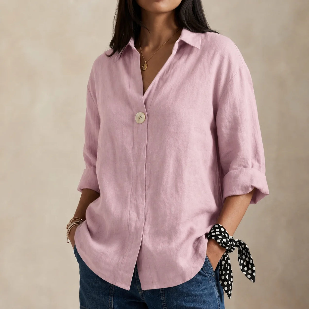 Close-up of the single button and V-neckline detail on the relaxed-fit linen blouse