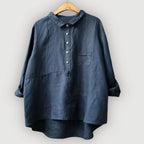 Close view of the navy blouse collar and button stand sitting open at the neckline