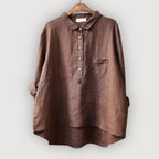 Rolled-up sleeve cuff detail on the brown linen blouse showing the oversized fit