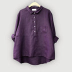 Back view of the violet linen blouse showing the dropped yoke seam and flowing silhouette