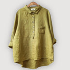 Olive green linen blouse with collar and button placket, displayed on a wooden hanger against a plain backdrop
