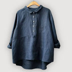 Navy linen blouse with collar, button placket and front pocket, shown on a timber hanger