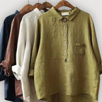 Four linen blouses in navy, brown, white and olive hanging together, displaying the full colour range