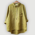 Front view of the olive linen blouse showing its dropped shoulders and high-low curved hem