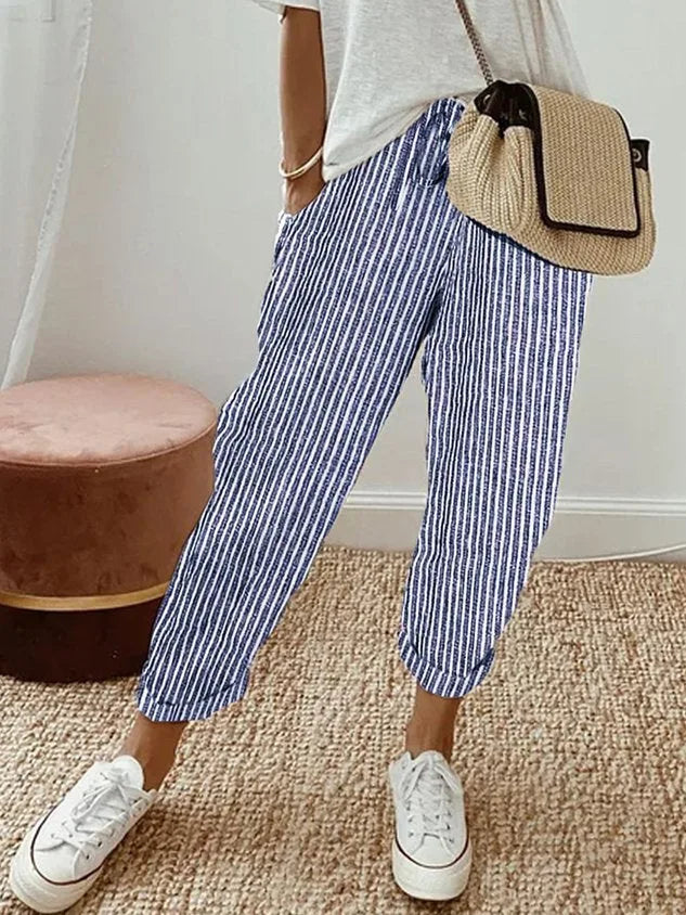 Blue and white striped relaxed pants with drawstring waist, cuffed hems and white sneakers