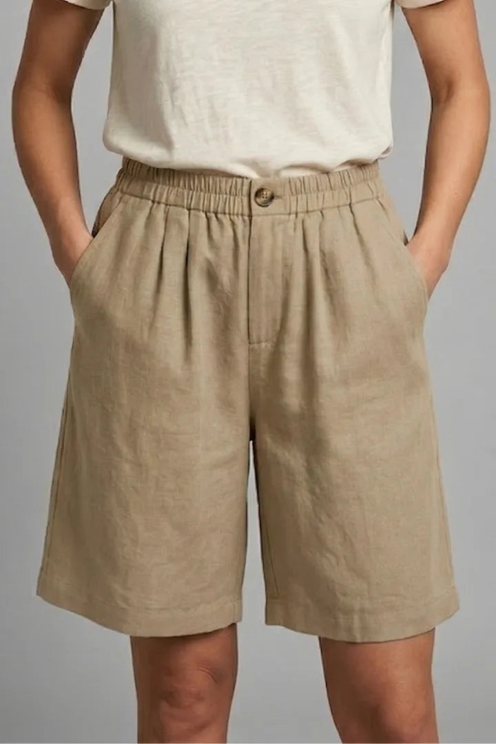 Close-up front view of khaki linen shorts showing fabric texture and roomy side pockets