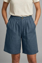 Close-up front view of navy blue linen shorts with elasticated waistband and button closure