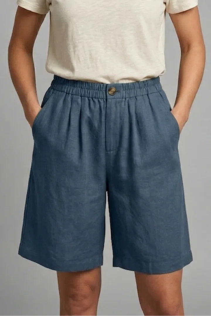 Close-up front view of navy blue linen shorts with elasticated waistband and button closure