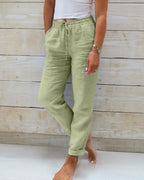 Sage green linen pants with elasticated drawstring waist and rolled hem, shown from the front