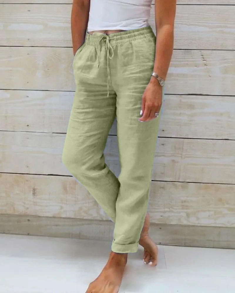 Sage green linen pants with elasticated drawstring waist and rolled hem, shown from the front