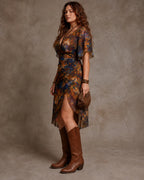 Side profile of the rust red floral midi dress showing the flutter sleeve, wrap skirt and thigh-high side slit