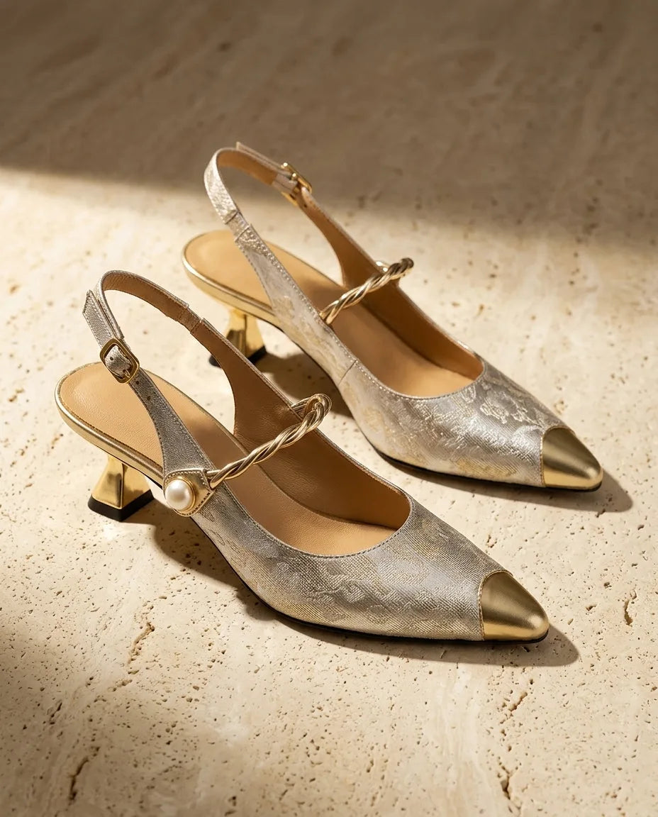 Pair of cream and gold jacquard slingback kitten heels with metallic pointed toe cap and twisted pearl-accented vamp strap.