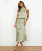 Front view of model wearing light green satin midi dress with draped halter neck