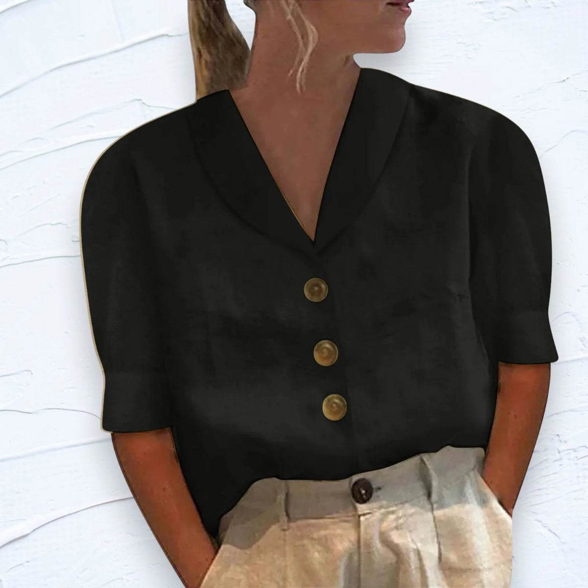 Black shawl-collar V-neck blouse with three buttons down the front, paired with beige pleated trousers