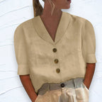 Beige shawl-collar blouse with button front, relaxed cut, styled with grey and cream trousers