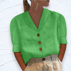 Green shawl V-neck top with cap sleeves and three-button placket, textured woven fabric close up