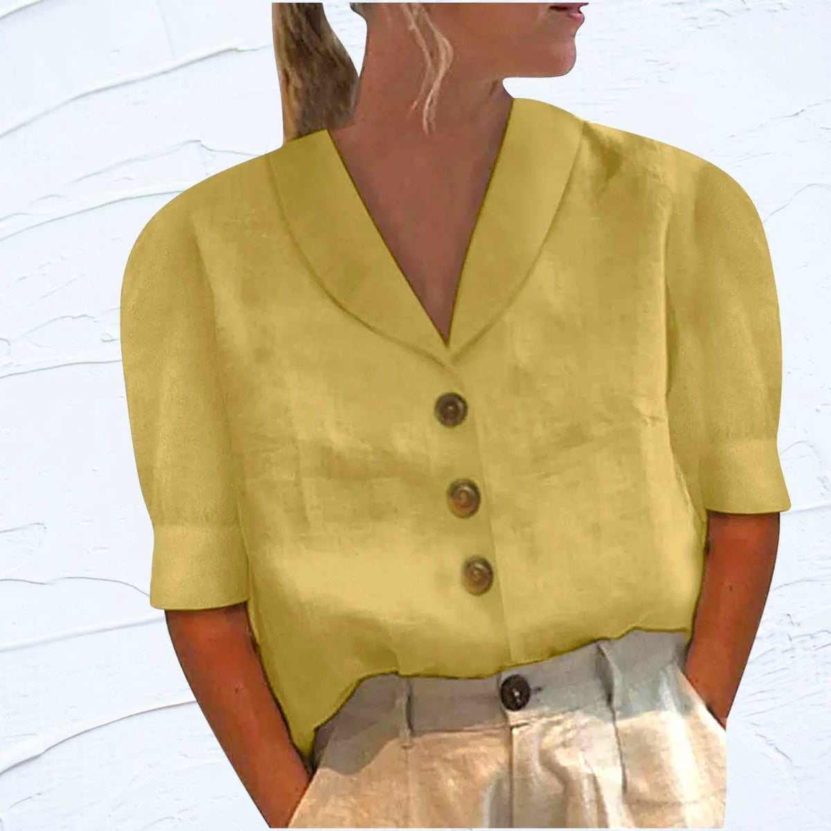 Yellow shawl-collar button-front top with cap sleeves, relaxed fit shown against a white wall