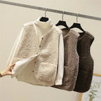 Side angle of a dark brown sherpa fleece vest on a hanger with a cream turtleneck jumper underneath
