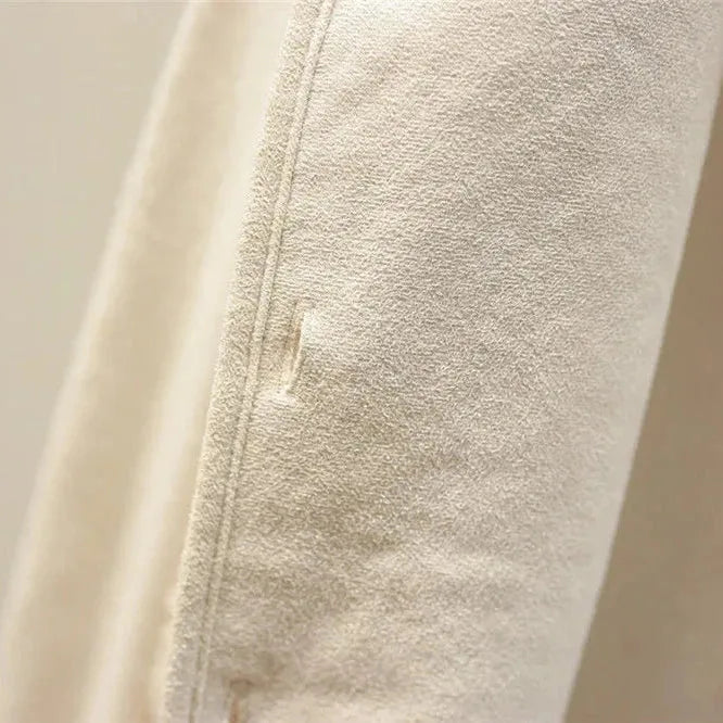 Close detail of the textured sherpa fleece fabric and button placket on a cream coloured vest