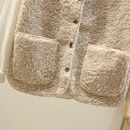 Three sherpa fleece vests in different colourways on a rack, showing the rounded hem and sleeveless cut from the front