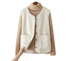 White sherpa fleece vest buttoned over a camel turtleneck jumper, showing the front patch pockets and wooden button closure