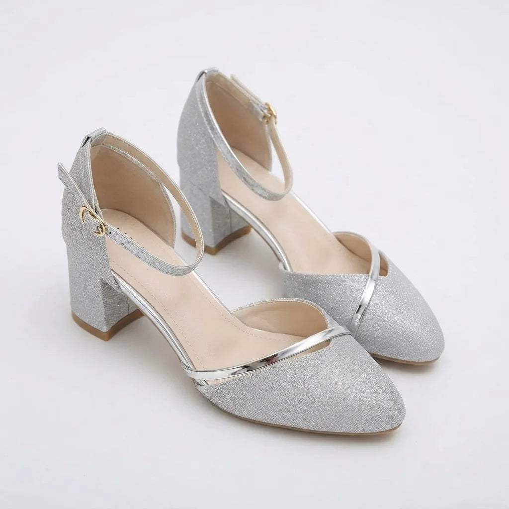 Front angled view of silver glitter sandals highlighting pointed toe and slim metallic strap detail