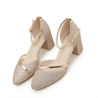 Close-up pair of gold glitter block heel sandals with metallic gold straps and buckle fastening