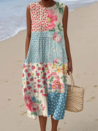 Woman on the beach wearing a sleeveless midi dress with mixed pink floral and polka dot patchwork panels