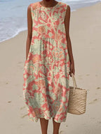 Sleeveless midi dress in a coral tone with an allover green and orange botanical floral print